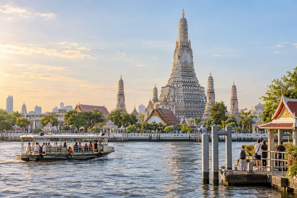 Wat Arun beside the Chao Phraya River with a local ferry in Bangkok